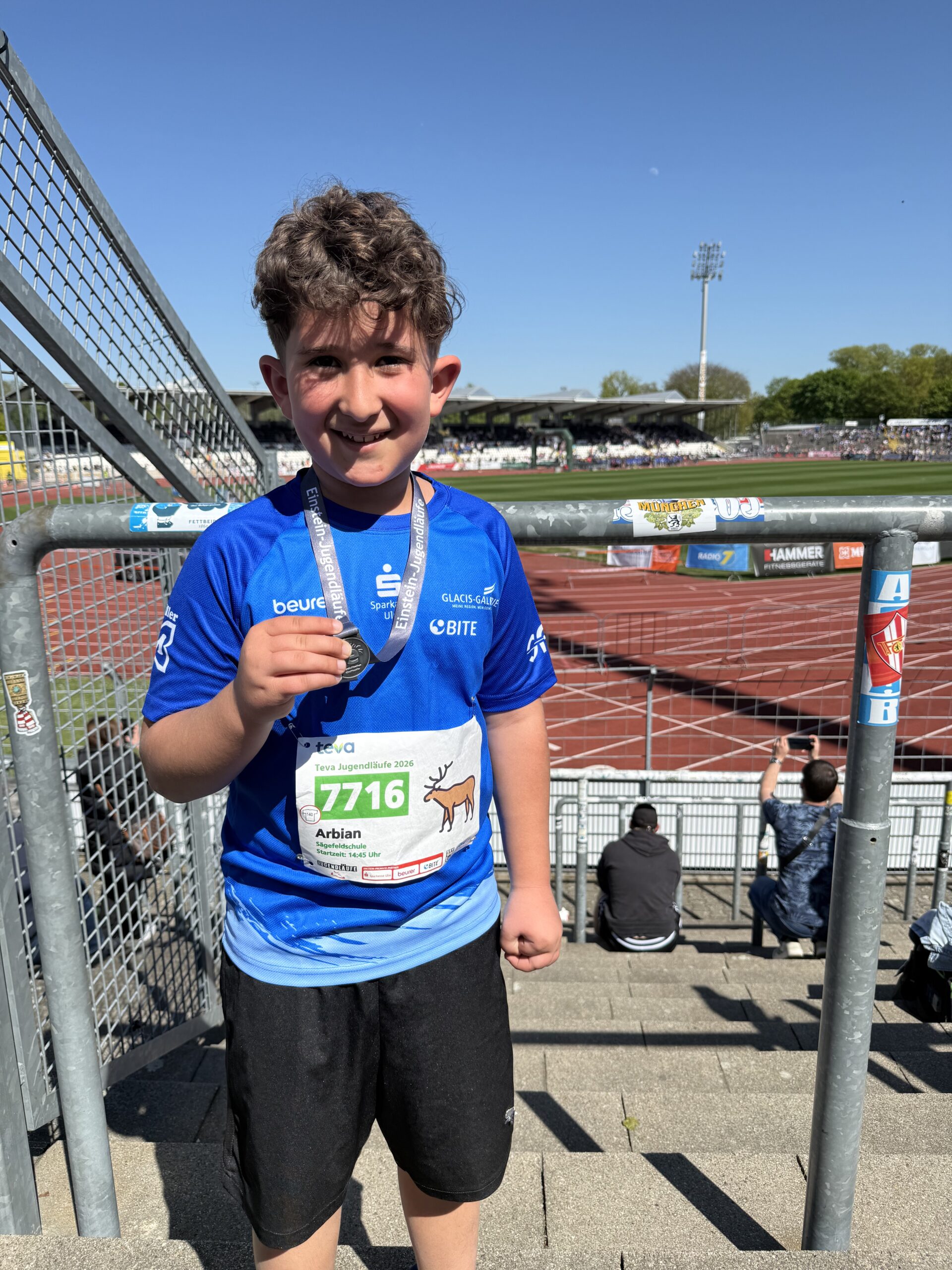 Schüler präsentiert stolz die Medaille